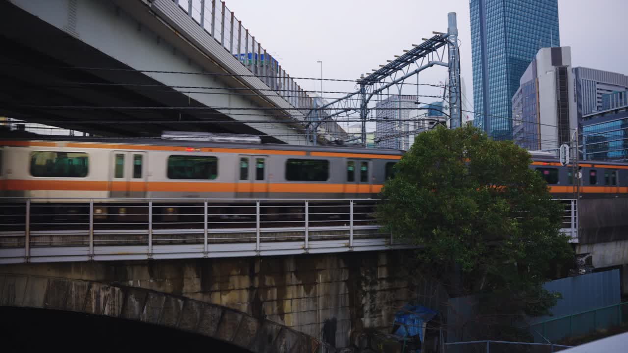 el tren de tokio en la línea jr sale de la estación de tokio con el fondo de la ciudad 4k