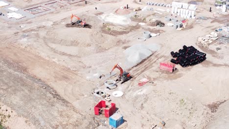 maquinaria de construcción pesada colocando tuberías de residuos de hormigón en el sitio de construcción de bienes raíces vista aérea descendente