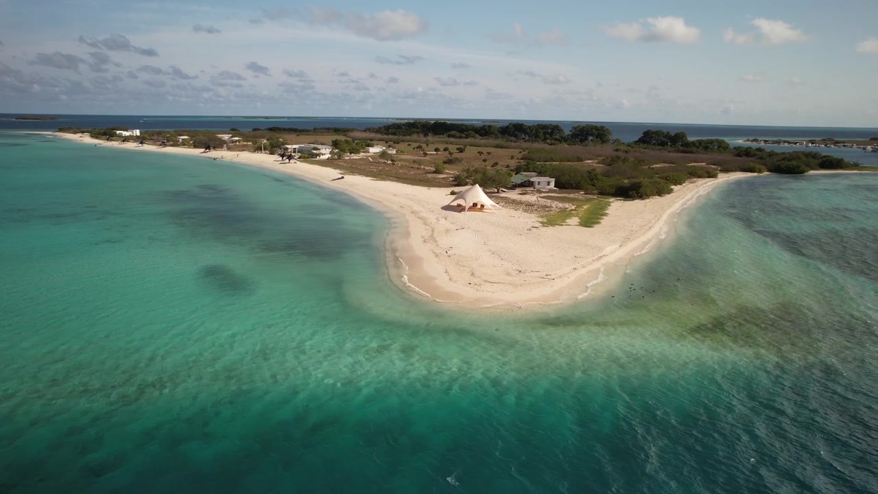 Tropical beach on Punta Madrisky in Los Roques with turquoise waters and sandy shores captured by drone