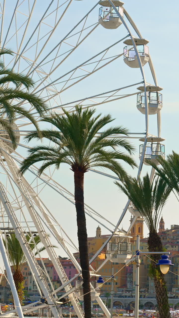 View of a white Ferris Wheel rotating on the beach in Menton, France