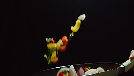 chef flips the vegetables on the pan