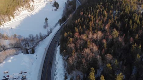 Blick-Von-Oben-Auf-Den-Schneebedeckten-Wald-Mit-Winterstraße---Drohnenaufnahme-Aus-Der-Luft