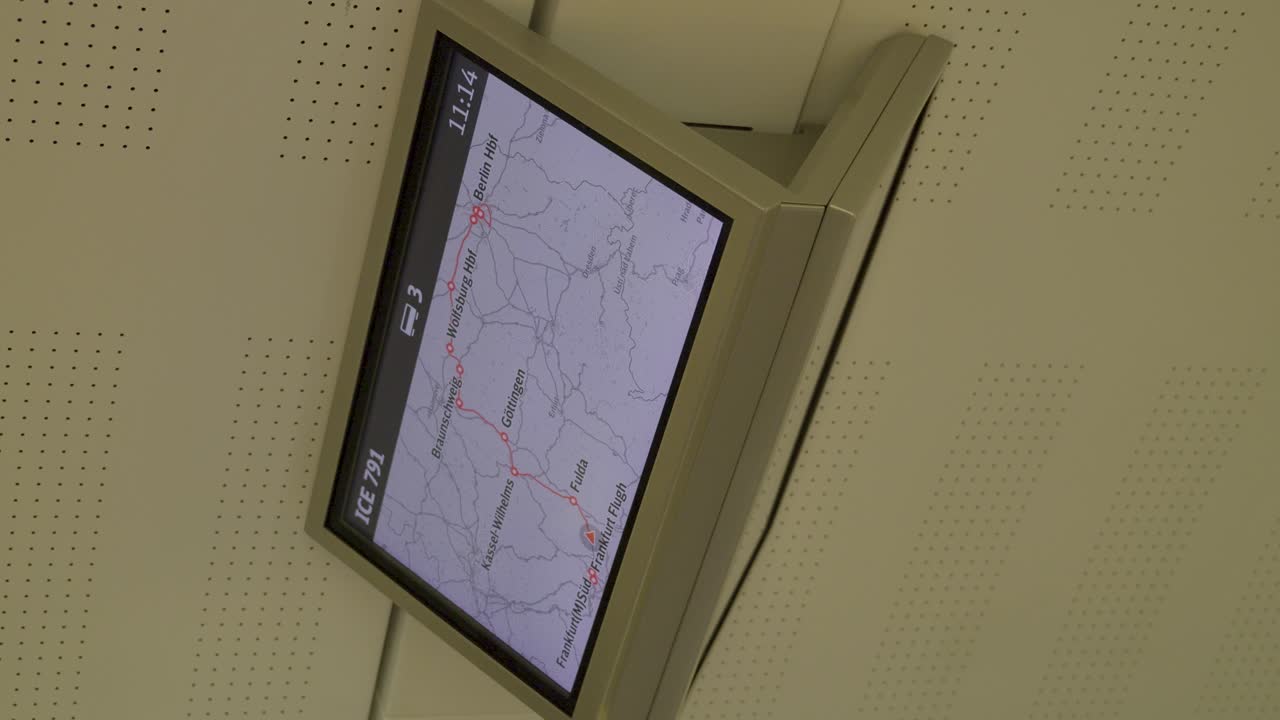 Inside a German ICE train, a digital map display shows train route information