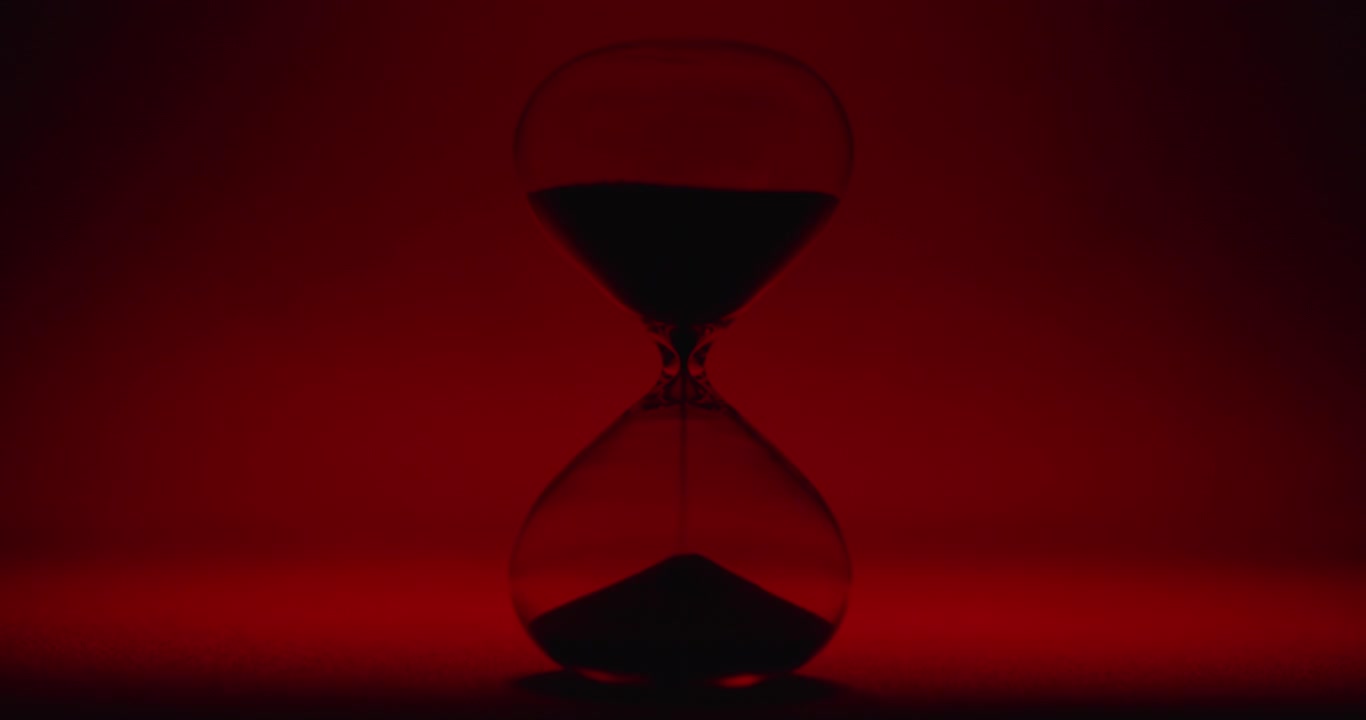 Hour glass on scarlet background