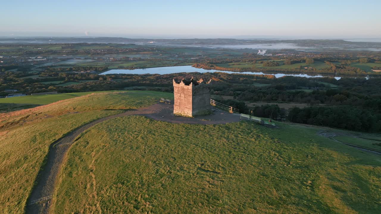언덕 꼭대기에 있는 돌 탑과 그 길로 이어지는 길, 그리고 가을에 새벽에 천천히 올라가는