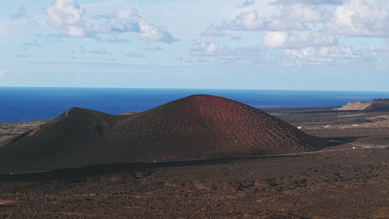 Vista drone di una grande caldera vulcanica con l'Oceano Atlantico sullo sfondo a Lanzarote, Spagna. Aerea, spazio per il testo.