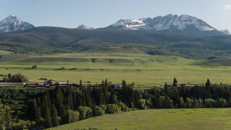 aerial drone sweeping scenic forest landscape of colorado snow-capped rocky mountains in the distance