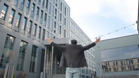 businessman celebrating success in front of modern office building