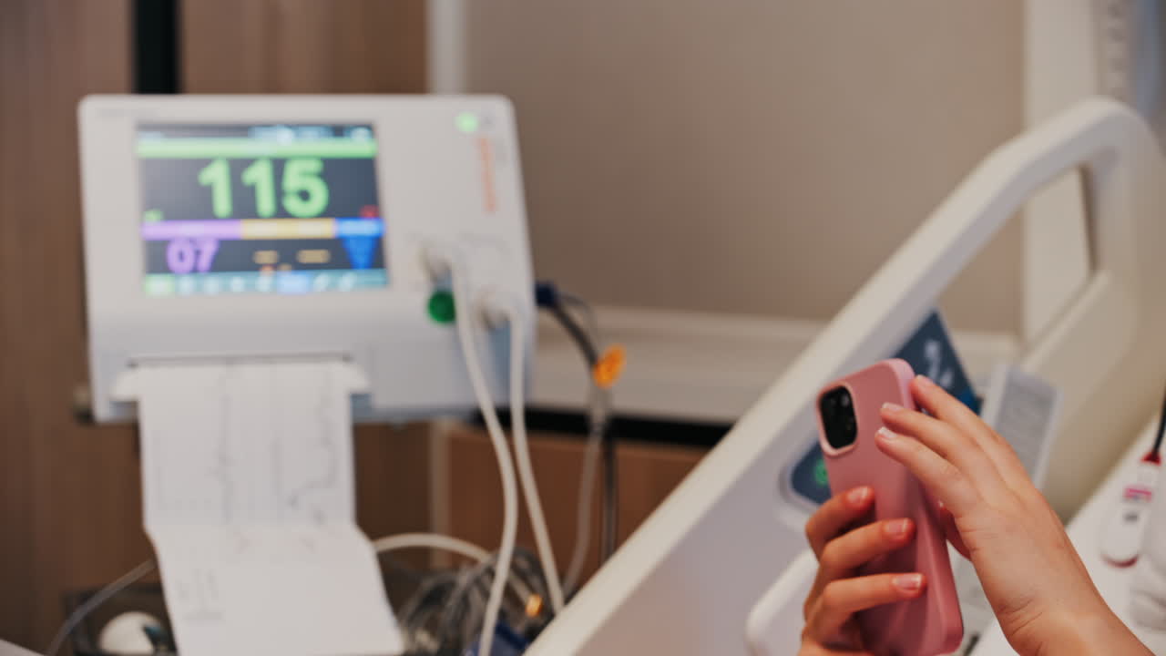Pregnant woman scrolling on her phone while doing a prenatal check-up at the doctor's office