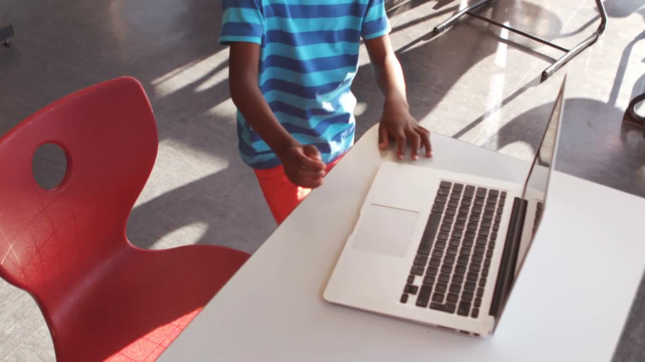 Schoolboy using laptop in classroom