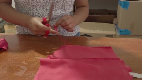 latin seamstress cutting a dress with scissors at a fashion designer's studio