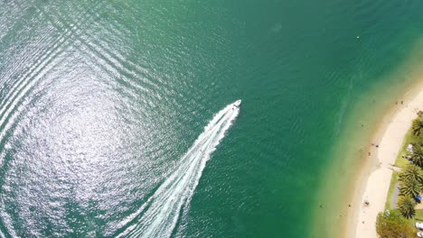 wakeboarding at tallebudgera creek - wakeboarder towed behind the motorboat across its wake - queensland, australia