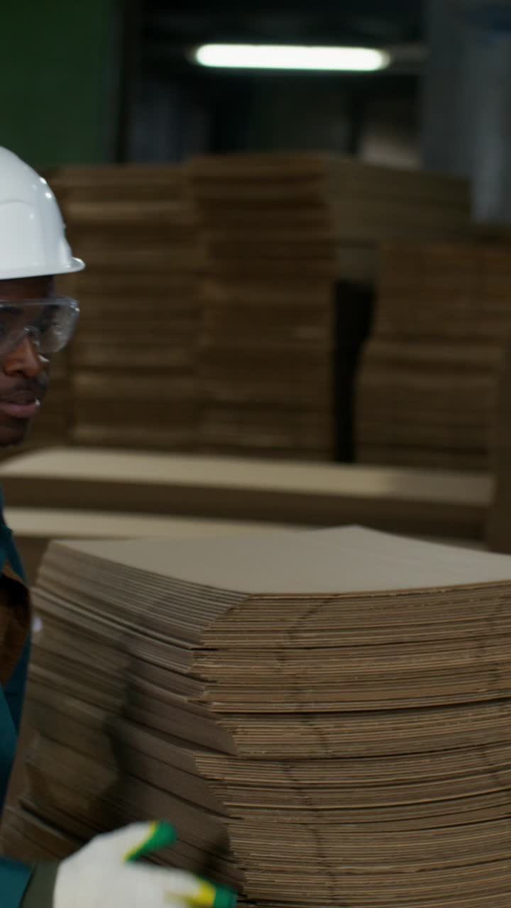 Worker Handling Cardboard Boxes in a Factory