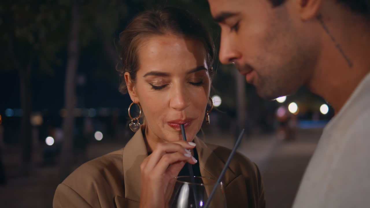 Dating woman drinking cocktail at street party closeup. Happy couple kissing