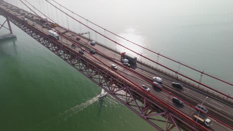 vehicles driving through ponte 25 de abril over tagus river in lisbon, portugal