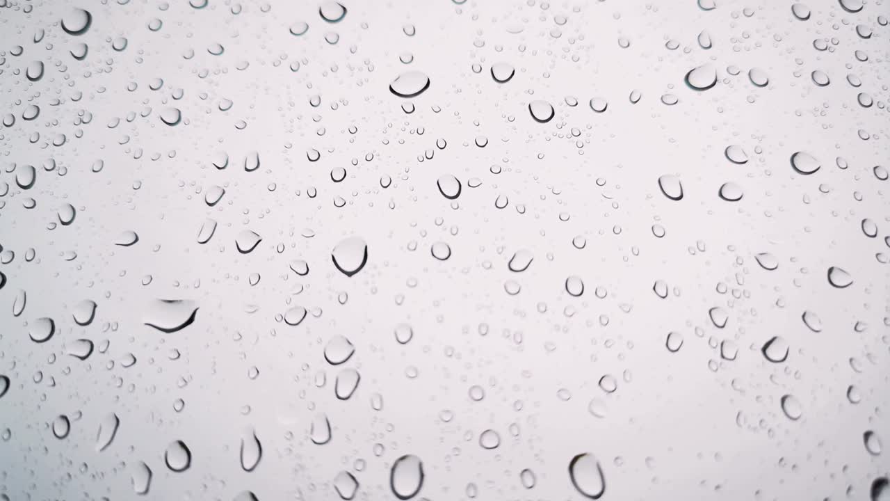 Rainwater drops Falling Down On the Window Glass, Rain Drops On The Windows Glass, Macro shot of water droplets falling.soft focus.shallow focus effect.