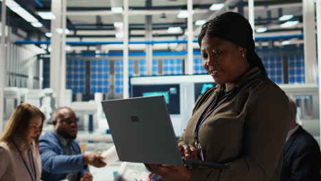 happy solar panels facility engineer using laptop to improve efficiency