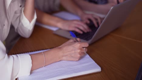 tres estudiantes maduros discutiendo un nuevo proyecto, tomando notas