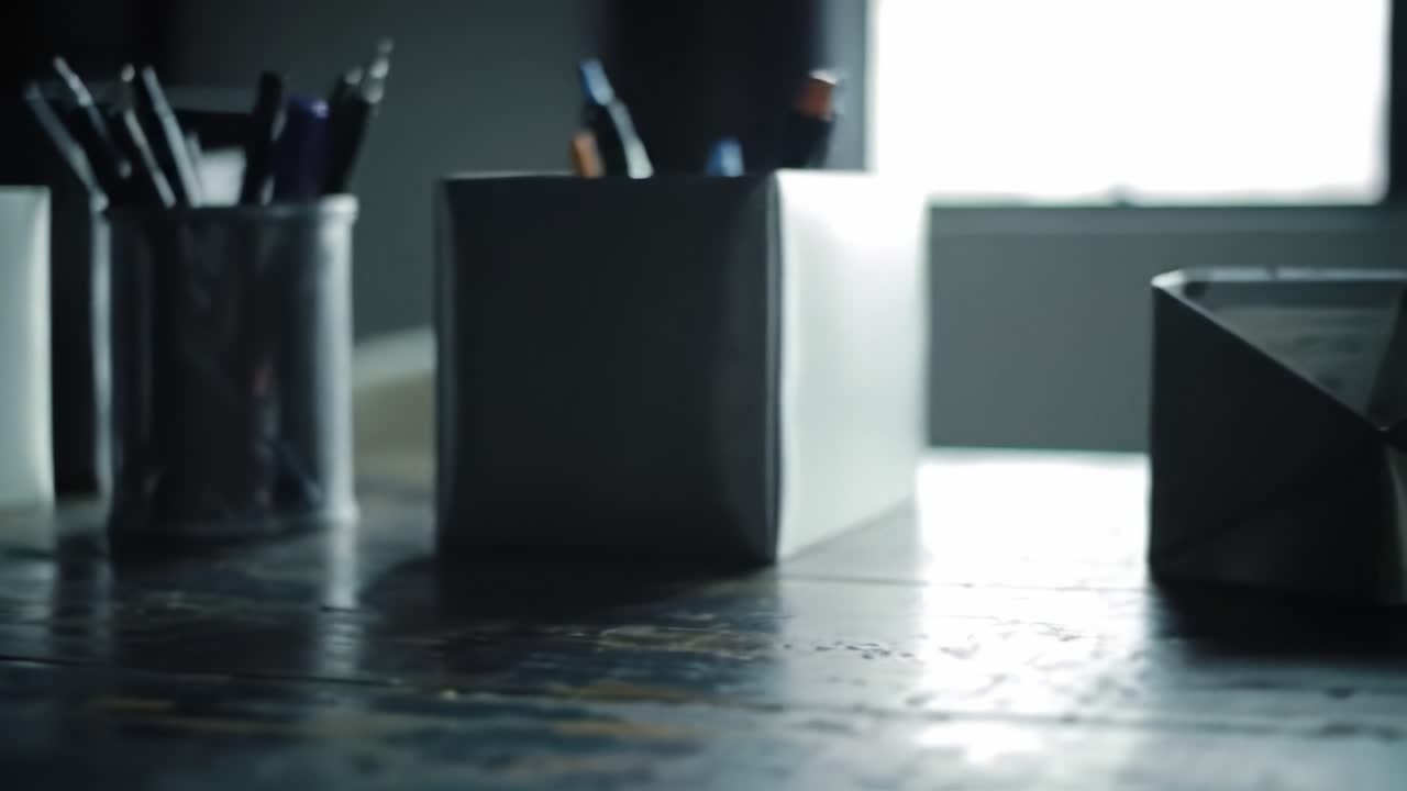 A Close-Up on Desk Organization: An Insight into Stylish Pen Holders and Accessories on a Rustic Table Surface Surrounded by Natural Light