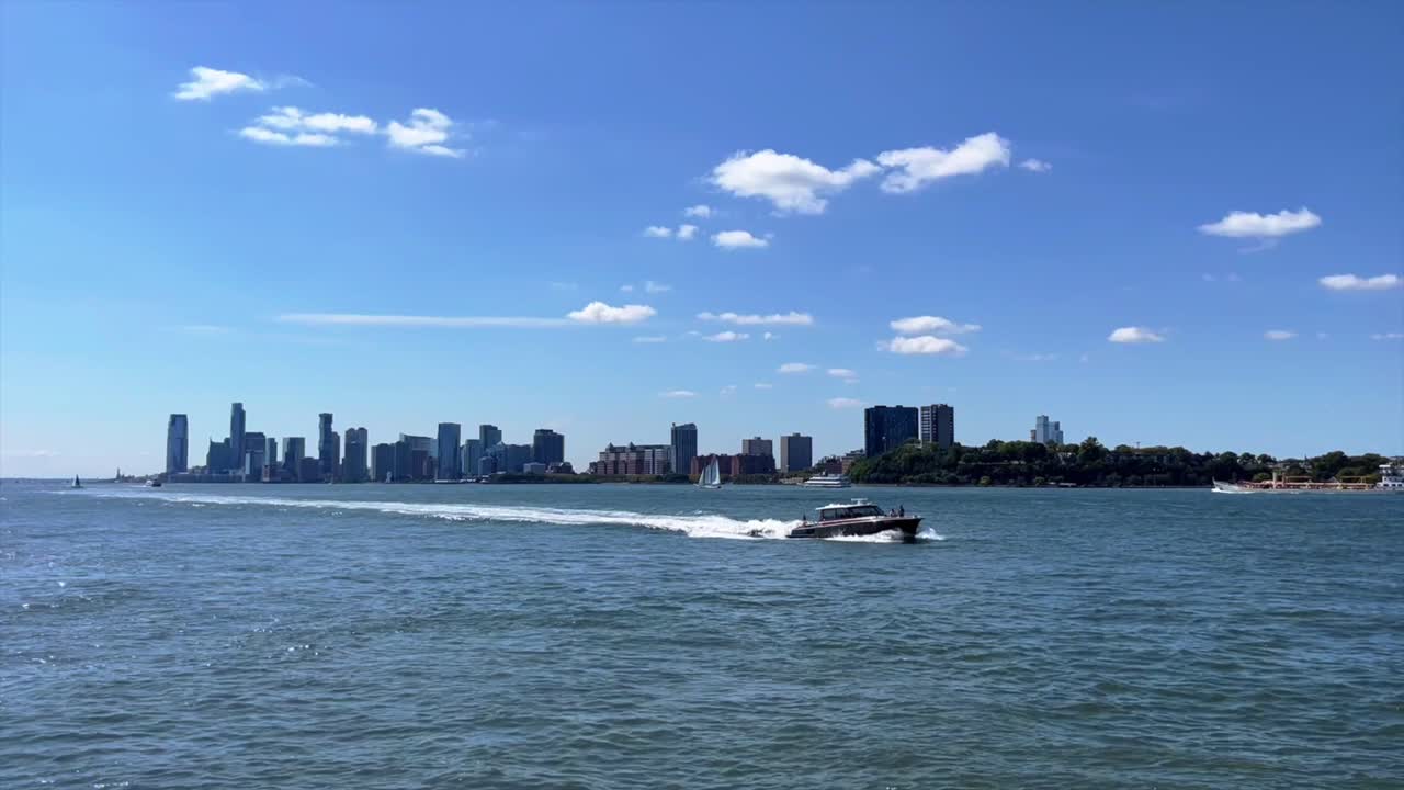 Boat travels along Hudson River, New Jersey skyline in background, view from New York City