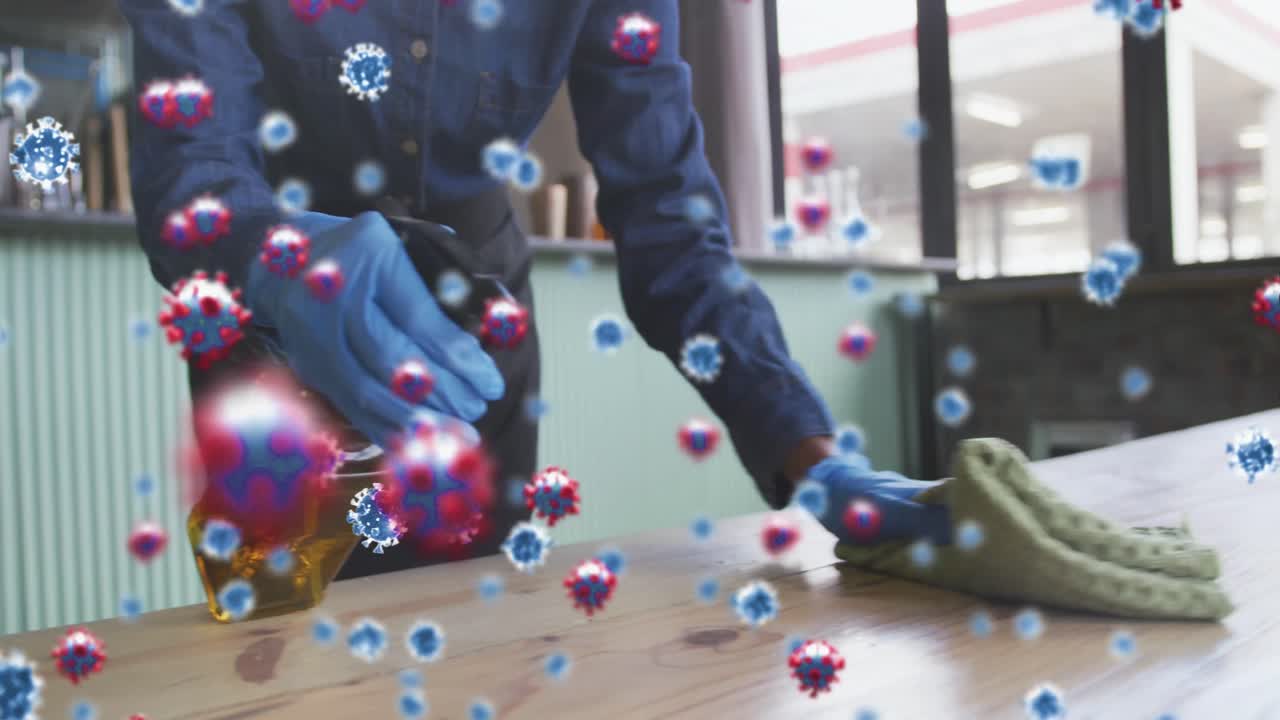 수술 장갑의 클리너 위에 코로나 19 세포의 애니메이션 스프레이로 책상 표면을 소독하는