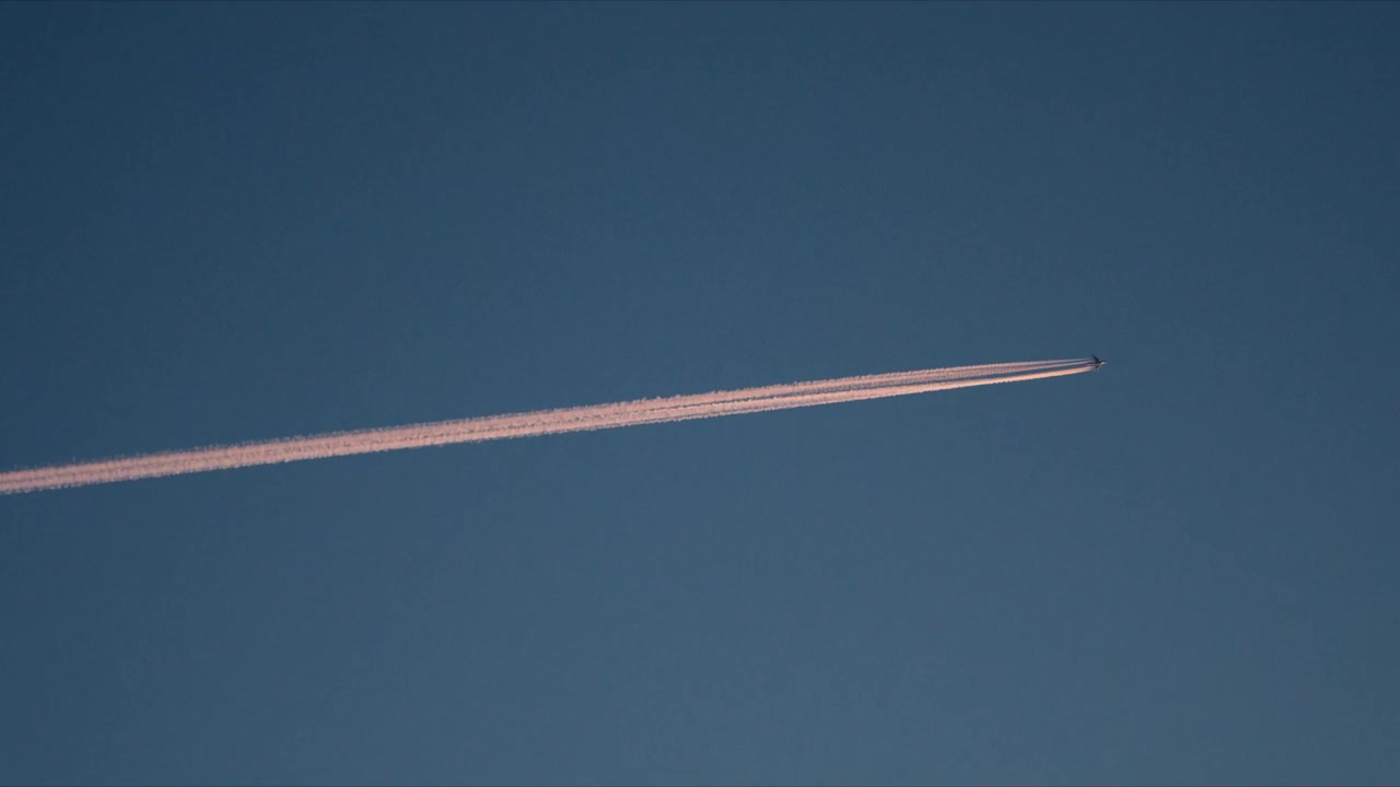 Jejak Kondensasi Pesawat Diagonal Membelah Langit Arktik Biru Jernih di Atas Norwegia
