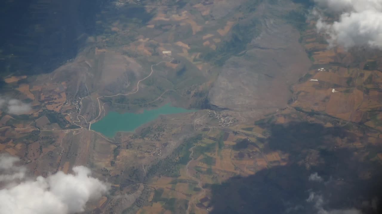 Aerial View of a Turquoise Lake and Mountainous Landscape