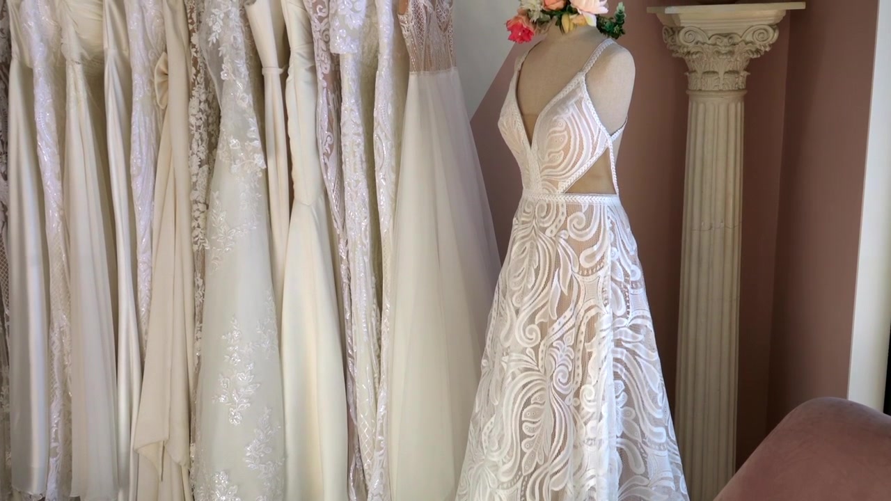 Una panoramica e un'inclinazione verso l'alto su un abito da sposa in un negozio di abiti da sposa.