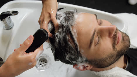 hombre lavándose el cabello