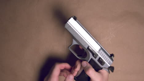 hands loading 9mm pistol with magazine and getting stuck