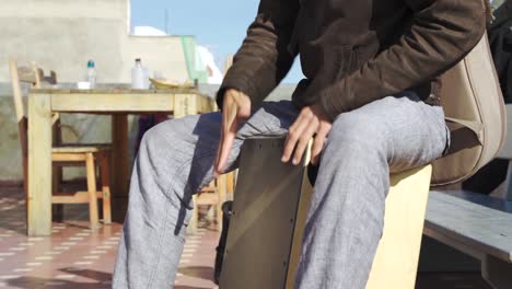 cinematic outdoor shot of a man playing the cajon in slow motion