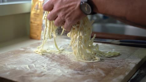 caucasian hand sprinkles flour on fresh home made pasta in slow motion