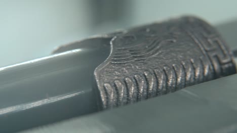un macro close-up de dos antiguos cuchillos de plata, arma antigua china, cuchilla histórica de época, viejo acero decorativo, daga tradicional, iluminación profesional, panela de video 4k cinematográfica a la derecha