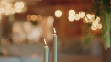 two lit taper candles glow gently in soft defocused background