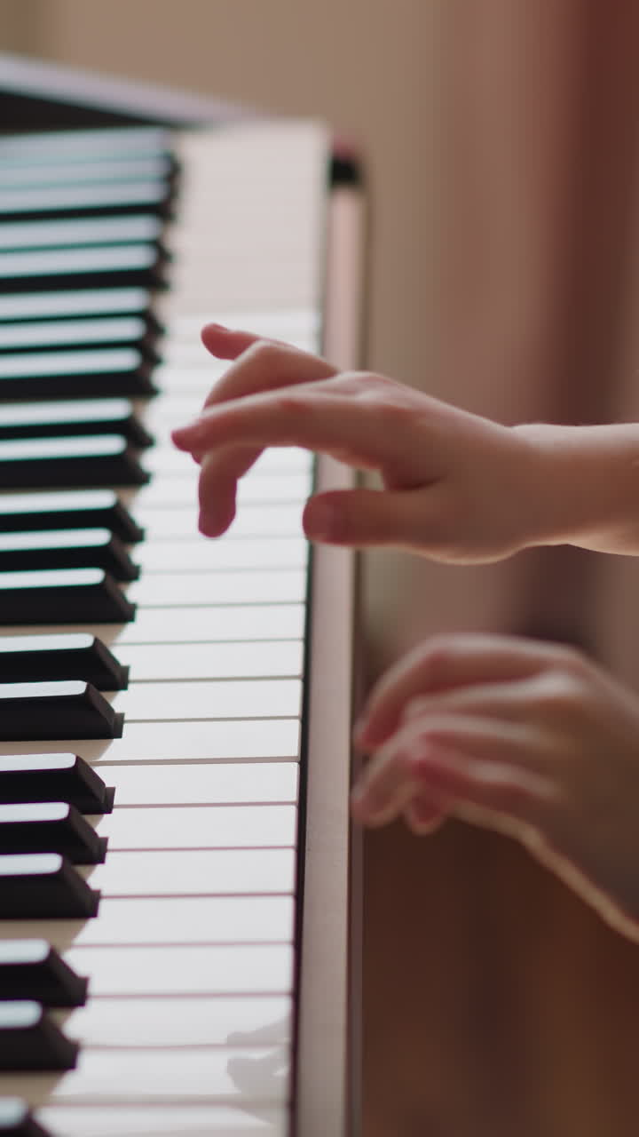 Little student plays melody on electrical piano keyboard in living room closeup. Schoolgirl learns musical theme on digital instrument at home