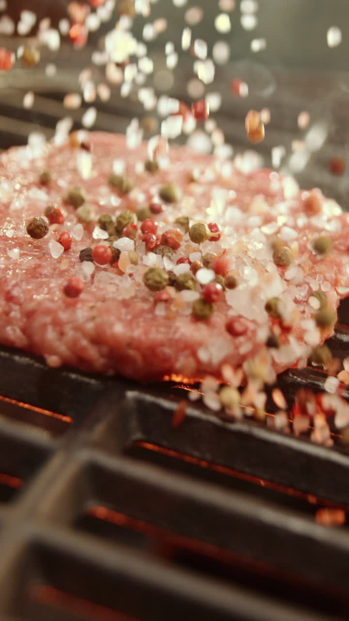 Meat being cooked on a grill with seasoning