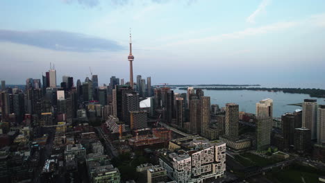 Aerial-view-away-from-downtown-Toronto,-sunset-in-Canada---pull-back,-drone-shot