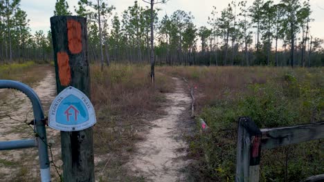 señal de sendero de florida en el poste de la cerca en el comienzo del sendero cerca de econfina creek con sendero de senderismo en segundo plano