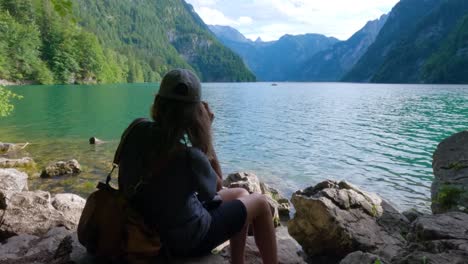 turystka robiąca zdjęcie na brzegu jeziora królewskiego, königssee w niemczech, bawaria