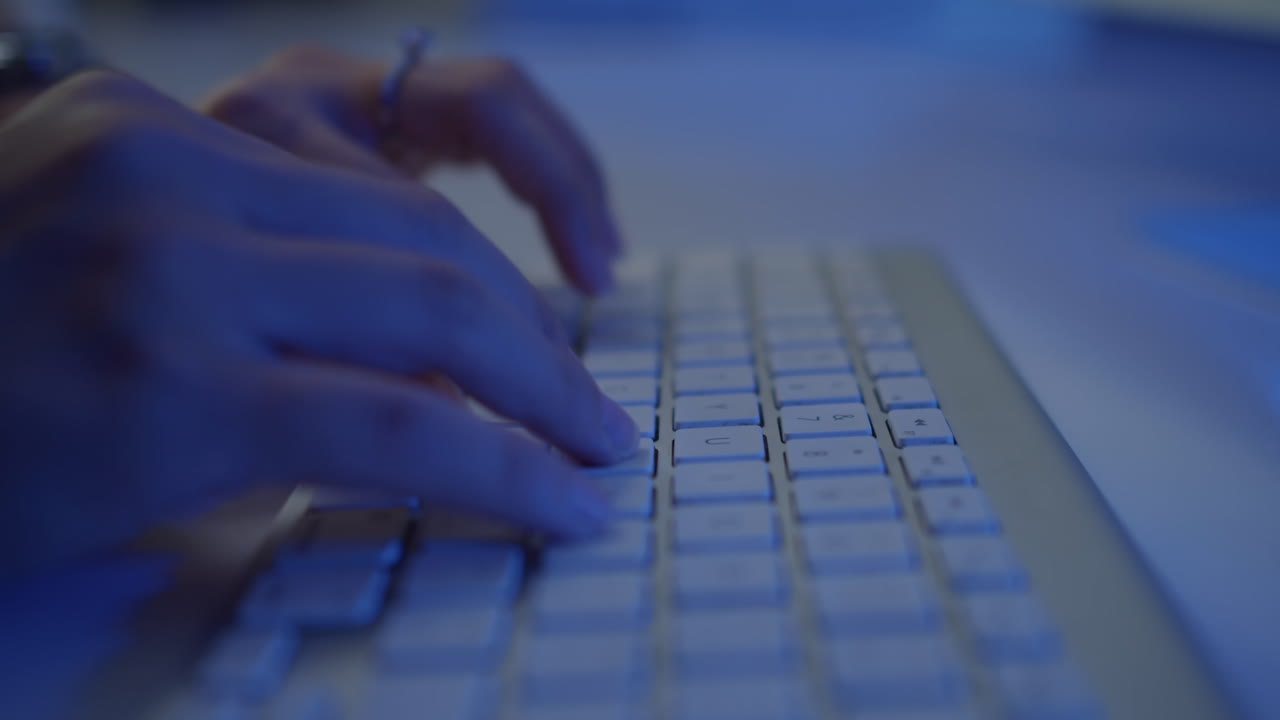 Hands of Workaholic or Hacker Typing on Keyboard in Neon