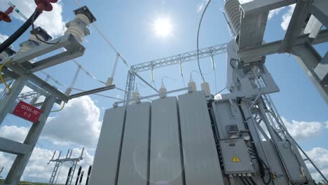 high voltage transformer against the blue sky. electric current redistribution substation