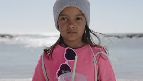 portrait of girl on beach holding beverage dressed in pink clothes