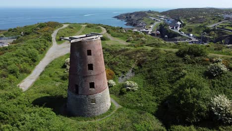 Amlwch-port-red-brick-disused-abandoned-windmill-aerial-view-North-Anglesey-Wales-slow-ascending