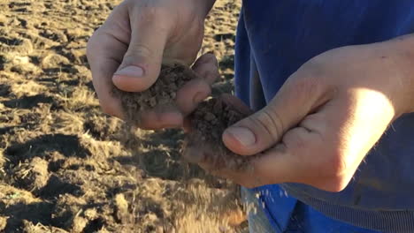 Slow-motion-of-dirt-falling-from-someone's-hands