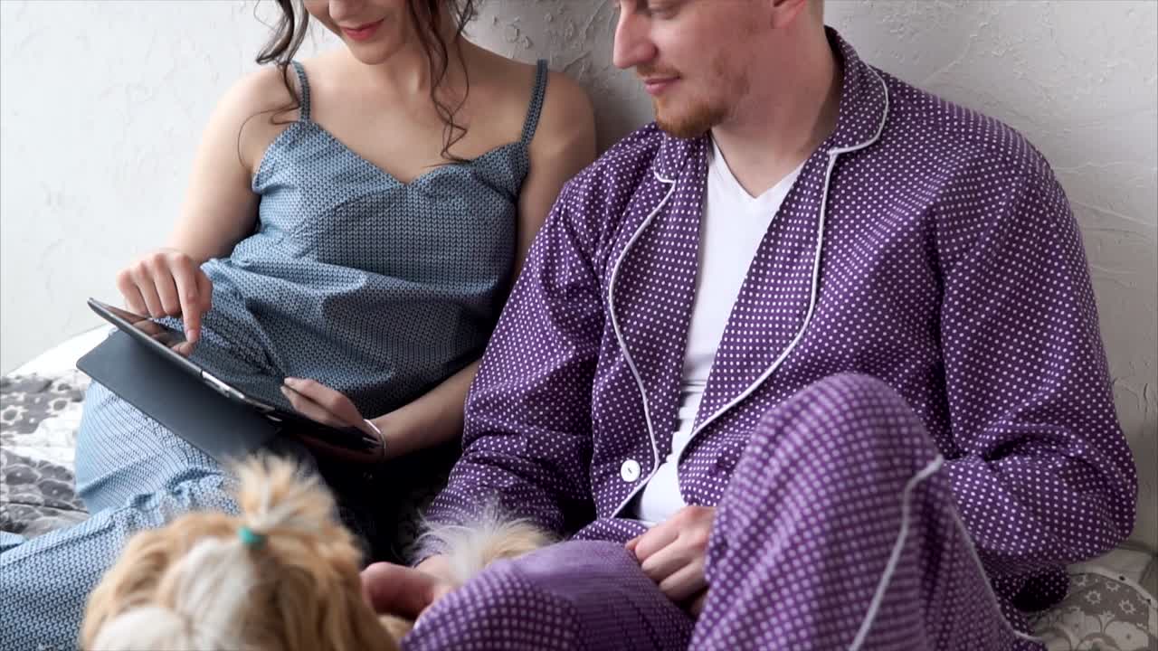 Couple relaxing with a dog in pajamas at home