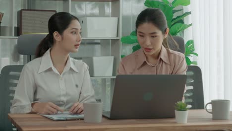 Two-young-enthusiastic-businesswoman-working-together-in-the-office-workspace.