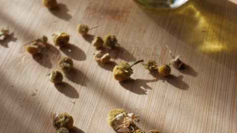 chamomile flowers laid out on a wooden surface with soft light casting shadows
