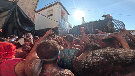 cascamorras festives of guadix 2024. in a crowd throwing colors and shouting chants.
