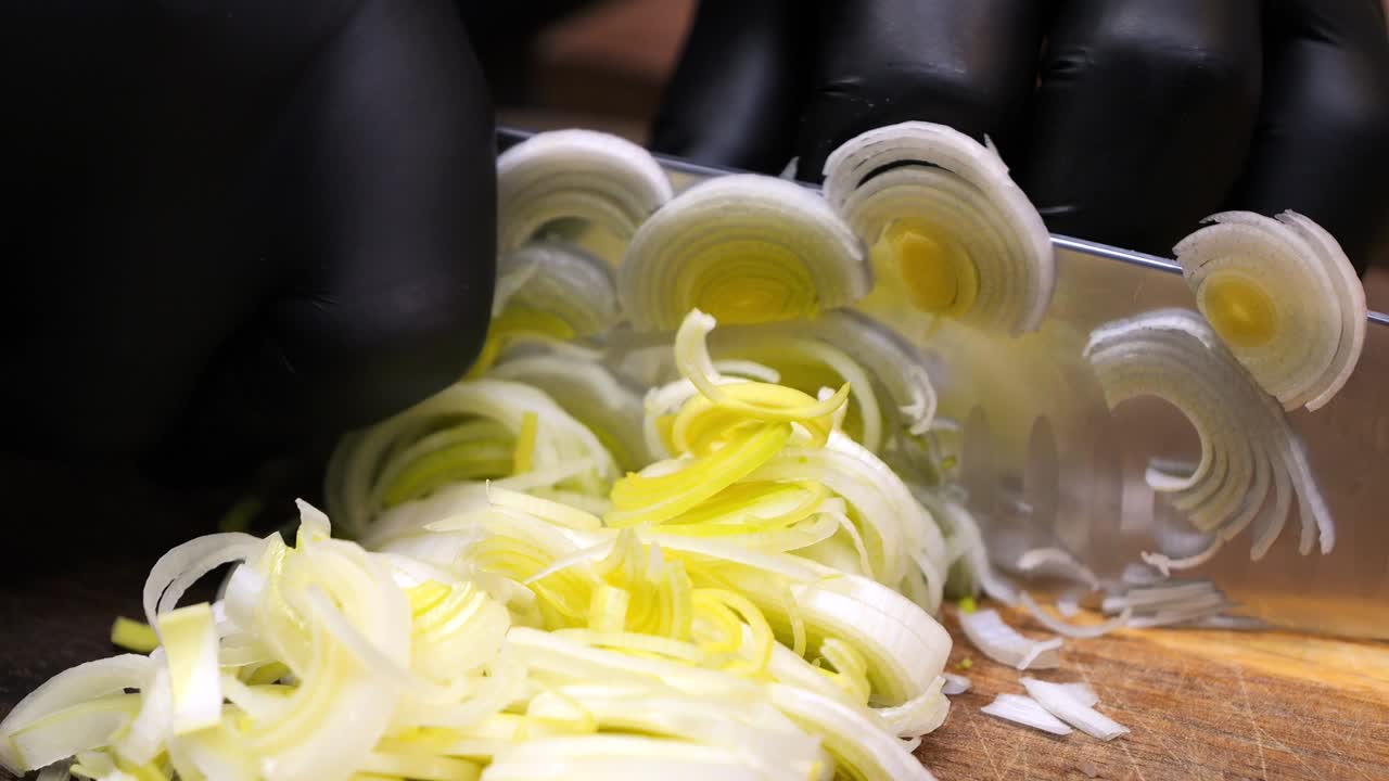 The chef slices leeks into thin slices