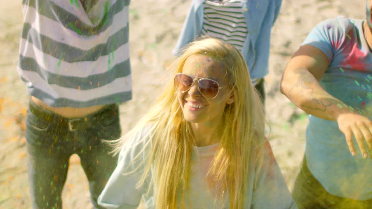 High Angle Shot of a Blonde Girl Throwing Colorful Powder in the Crowd Amidst Hindu Holi Festival Celebrations. They Have Enormous Fun on this Sunny Day.